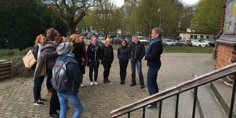 Stadtführerin A. Zimmermann mit Touristengruppe vor dem Eingang einer Kirche bei Stadtbilderklärung.