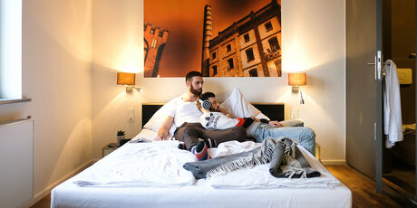 Zweibettzimmer im Hostel mit zwei jungen Männern auf dem Bett