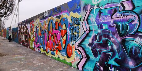 Mit Graffiti bemalte Hinterlandmauer der ehemaligen Grenze im Mauerpark