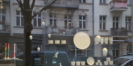 Schaufenster des Ladengeschäftes feines weißes mit sich spiegelnden Häuserfassaden