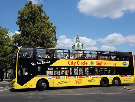 Gelber Cabrio-Buss (Doppeldecker) mit Touristen auf Tour im Berliner Zentrum