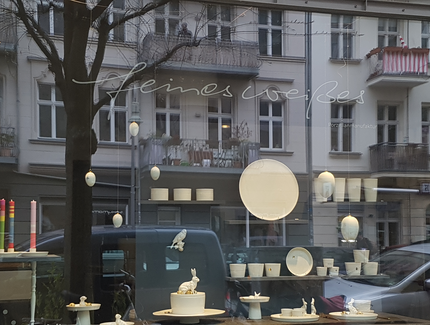 Schaufenster des Ladengeschäftes feines weißes mit sich spiegelnden Häuserfassaden