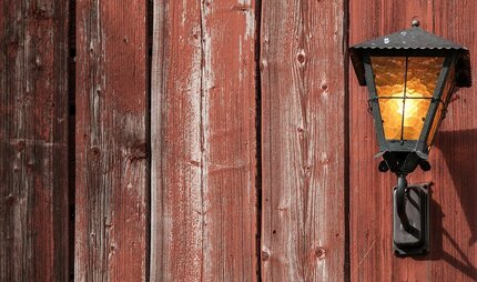 Laterne vor einer Holzwand