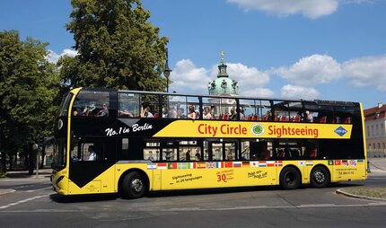 Gelber Cabrio-Buss (Doppeldecker) mit Touristen auf Tour im Berliner Zentrum